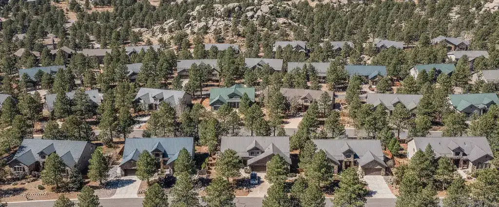 Well-maintained residential rooftops in Prescott, Yavapai County, Arizona, with pine-dotted hills and granite outcrops beyond